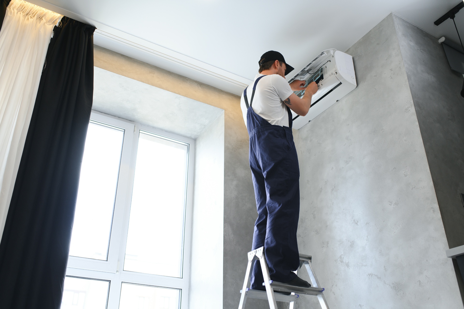 smiling-young-male-electrician-repair-conditioner-2025-03-14-19-42-15-utc 1